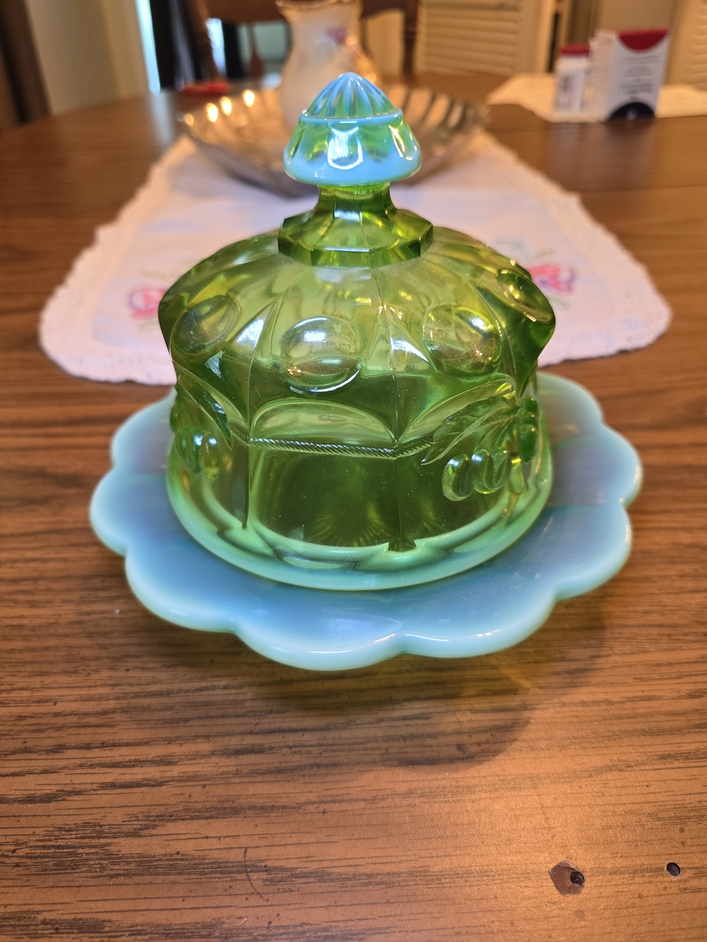 Mosser Glass covered butter dish in a green opalescent cherry and cable pattern.